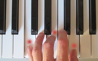 Fingers pressing down a chord